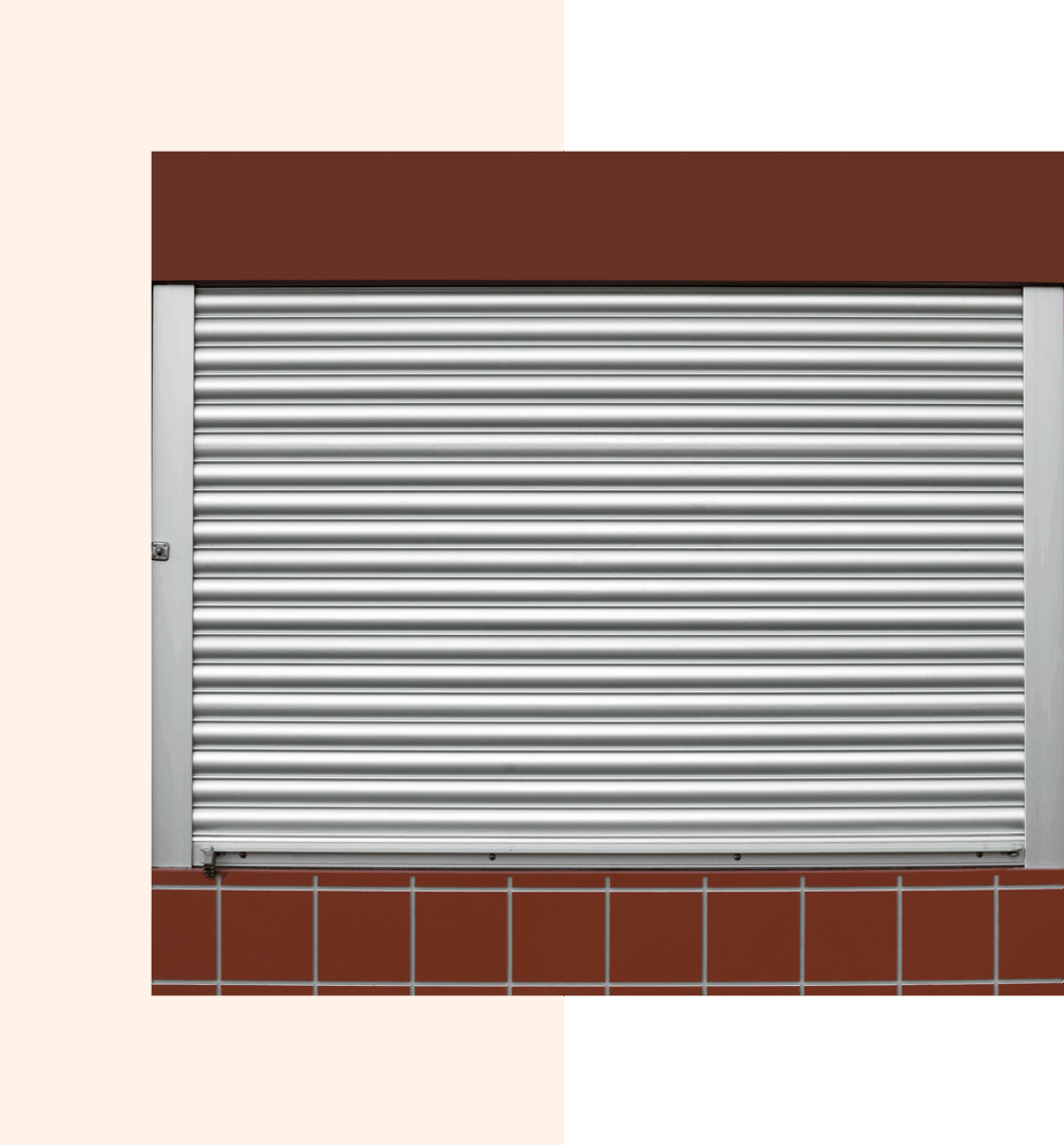 Metal roller shutter on brown-tiled wall.