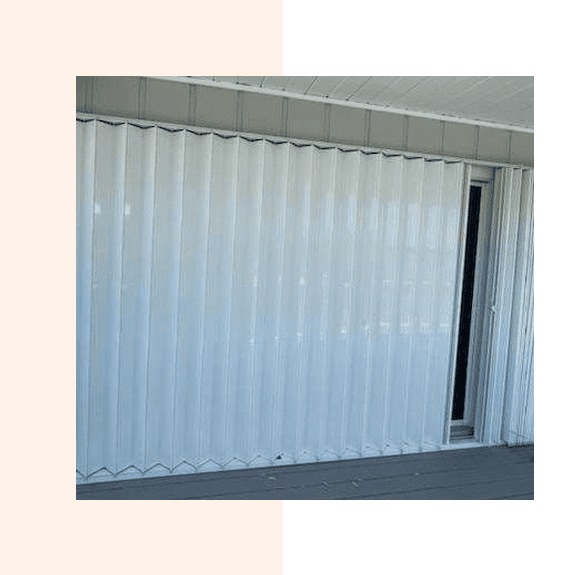 White vertical blinds partially open over a window.