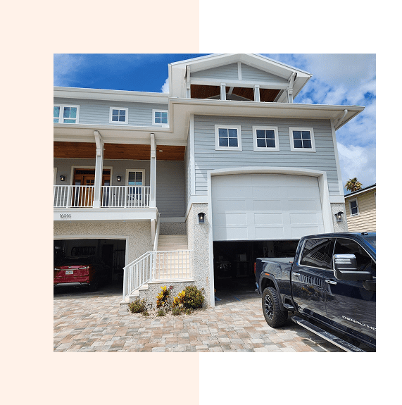 Modern two-story house with garage and parked black truck.