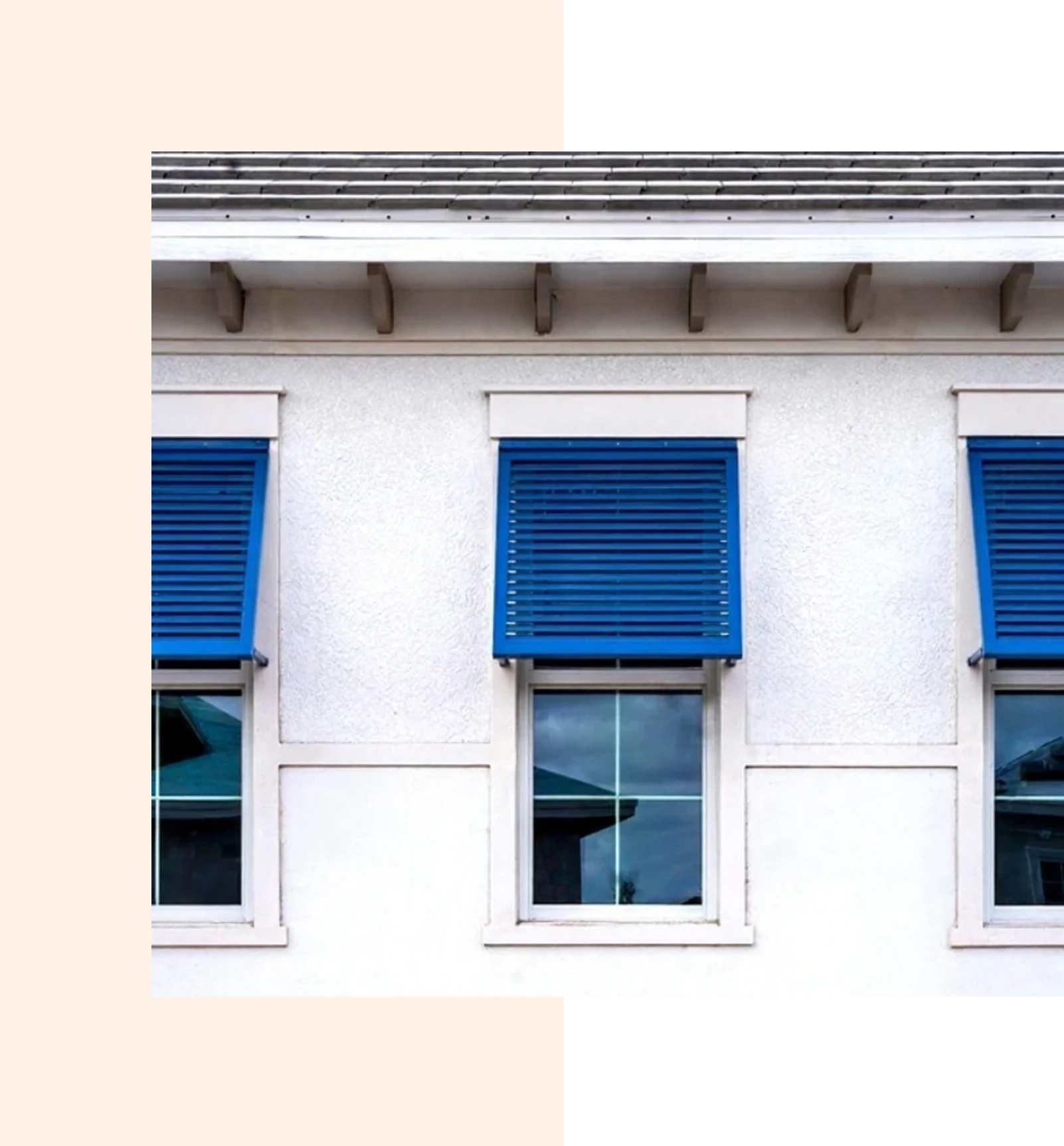 White building facade with three blue-shuttered windows.