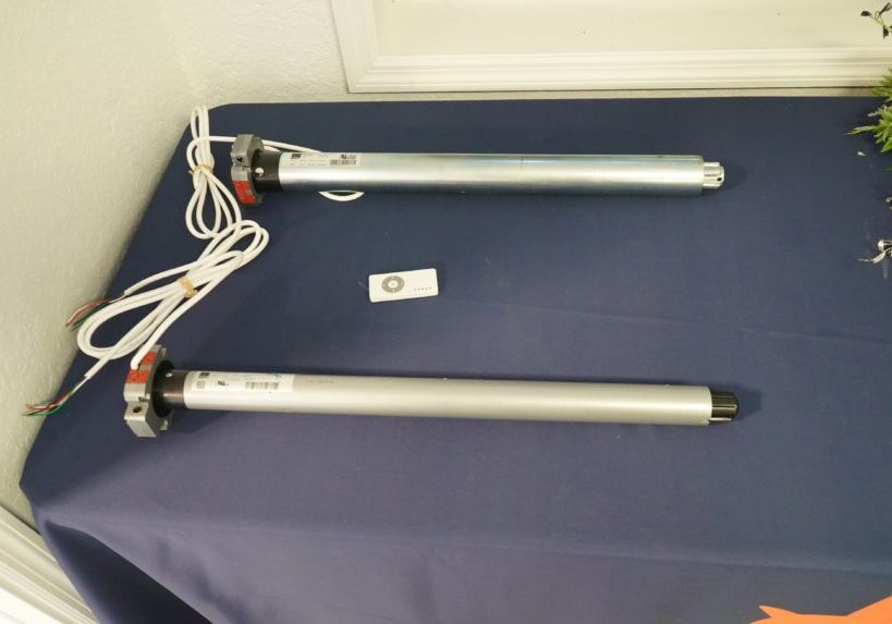 Two motorized roller shades on table.