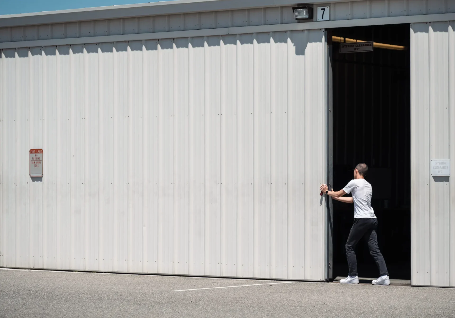 Person opening large white garage door.