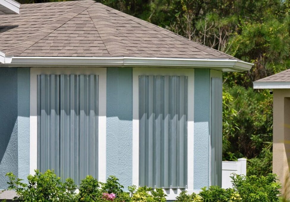 Blue house windows protected by storm shutters