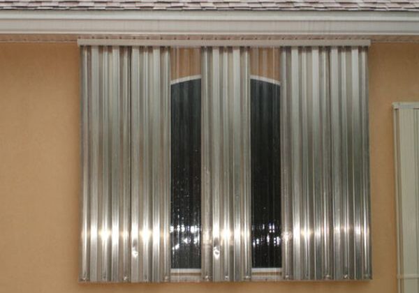 Metal hurricane shutters covering window exterior.